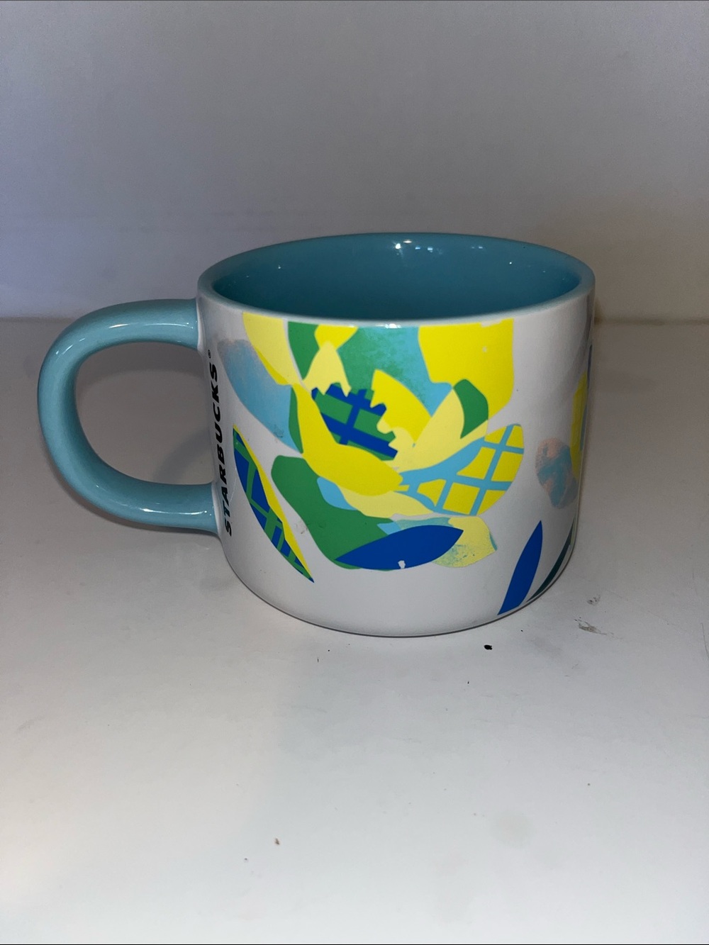 Starbucks White Ceramic Mug with Blue Interior and Yellow Floral Accents